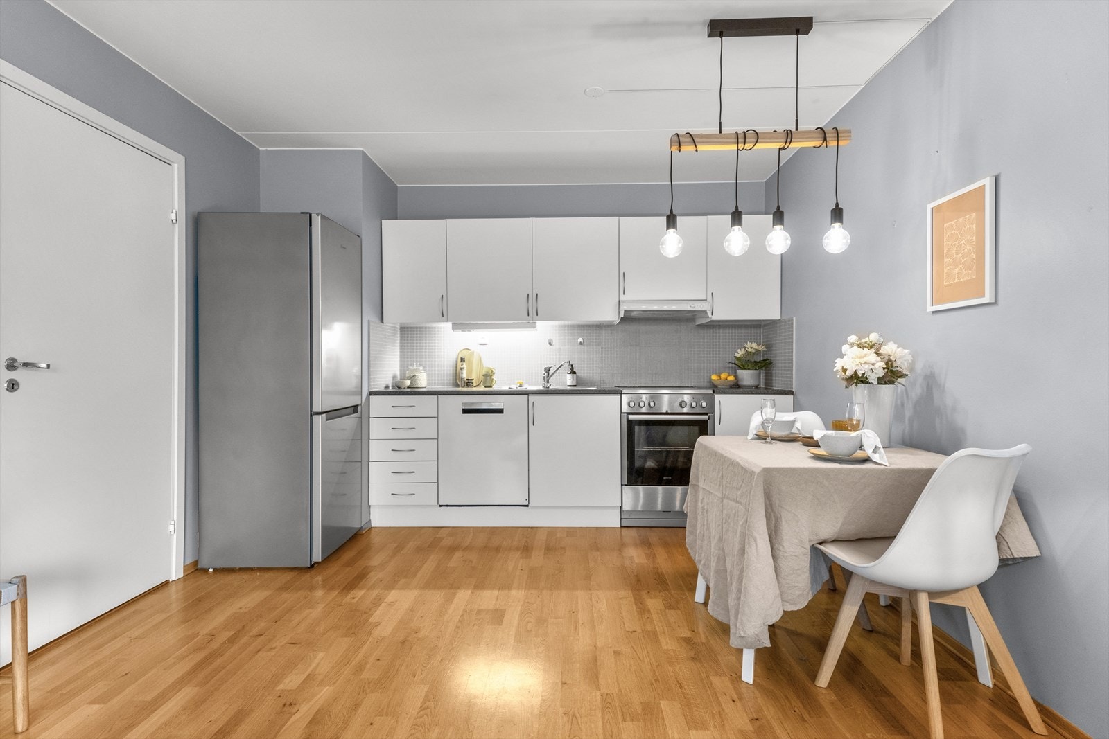 Leiligheten har et lyst kjøkken med glatte fronter og foliert benkeplate. Galleribilde