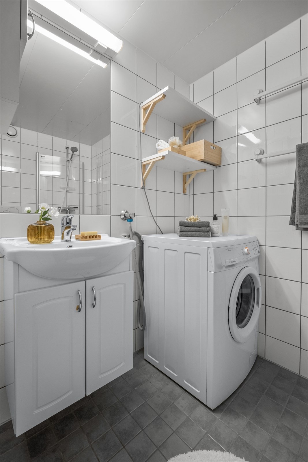 Innredning med vegghengt klosett, servantinnredning, servant med ettgreps blandebatteri, dusjdører, dusjarmatur, opplegg og plass til vaskemaskin. Galleribilde