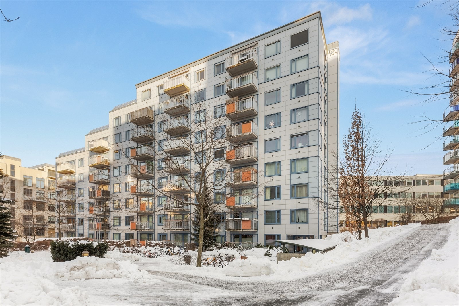 Tomten er pent opparbeidet med beplantning, trær, benker og interne stikkveier til innganger. Galleribilde