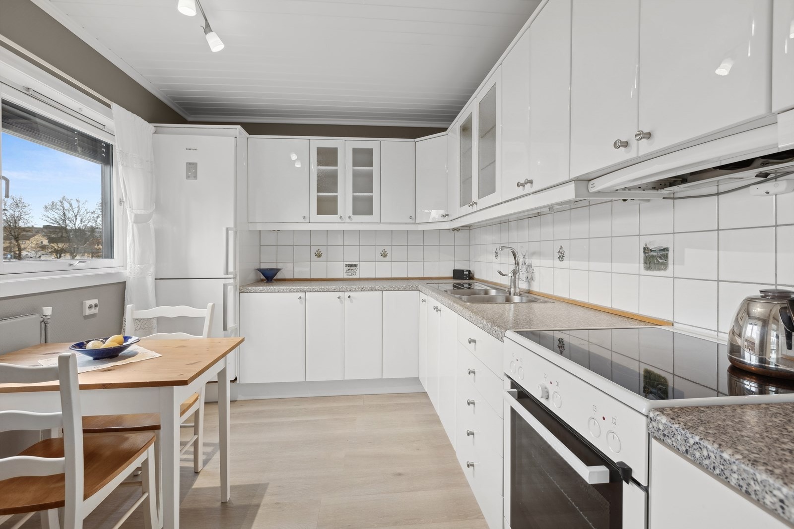 Kjøkkenet har tidløs stil med hvite, glatte fronter i høyglans utførelse. Galleribilde