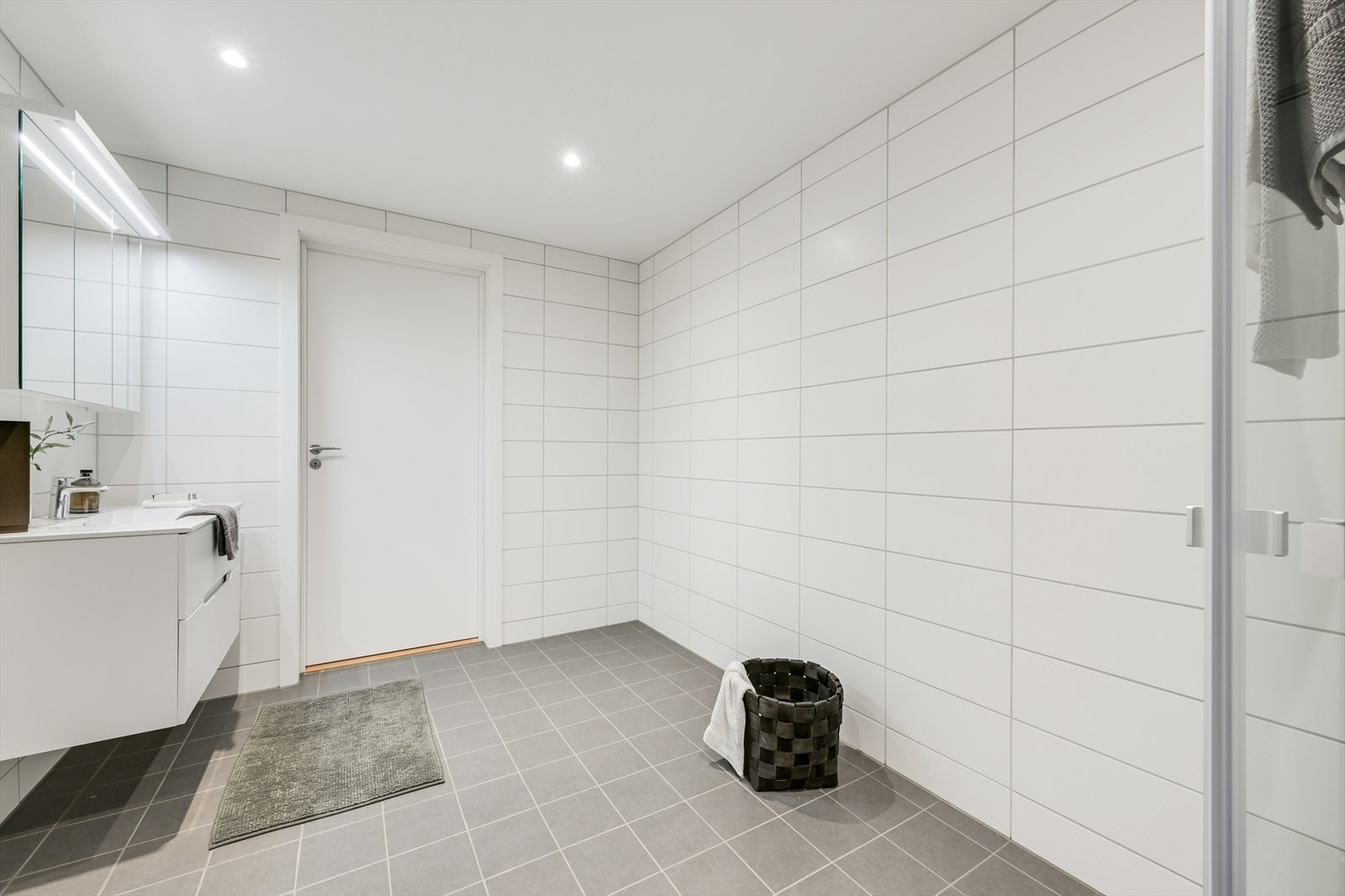 Flislagt hovedbad med elektriske varmekabler i gulv og downlights i himling. Galleribilde