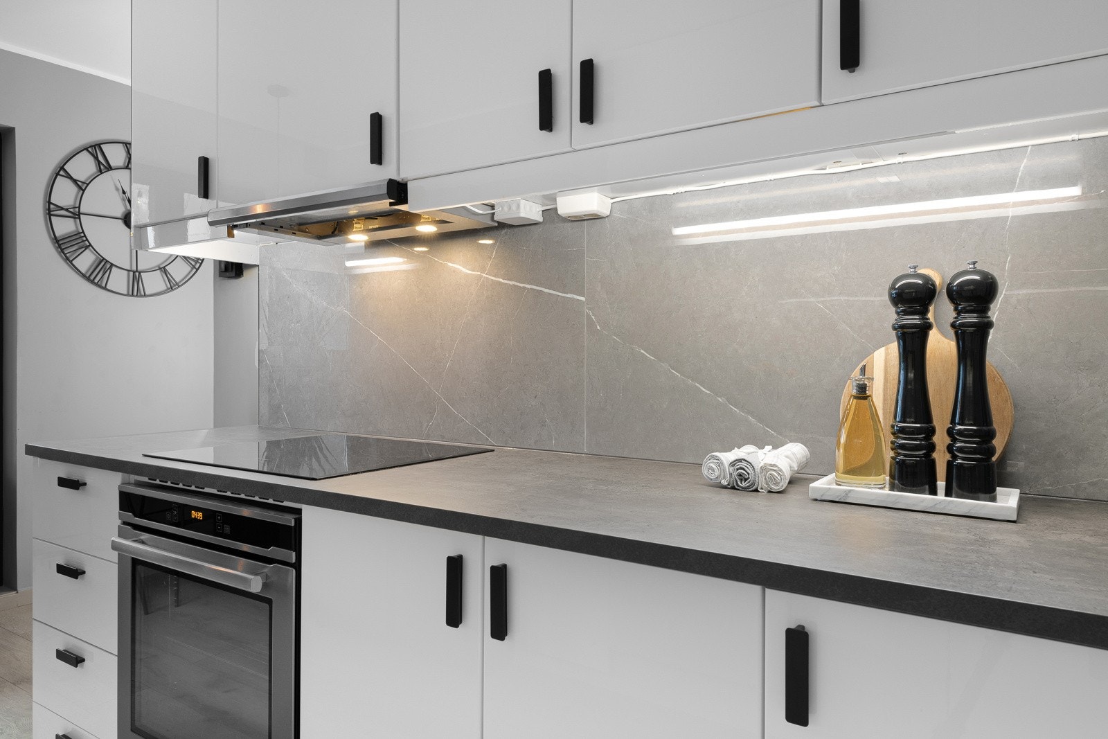 Kjøkkenet har en skjermet arbeidssone, men ligger i åpen løsning mot deler av stuen. Gulvet er lagt med sømløs overgang fra både entré og stue, og veggene er malt i samme gråfarge som øvrige rom. Galleribilde