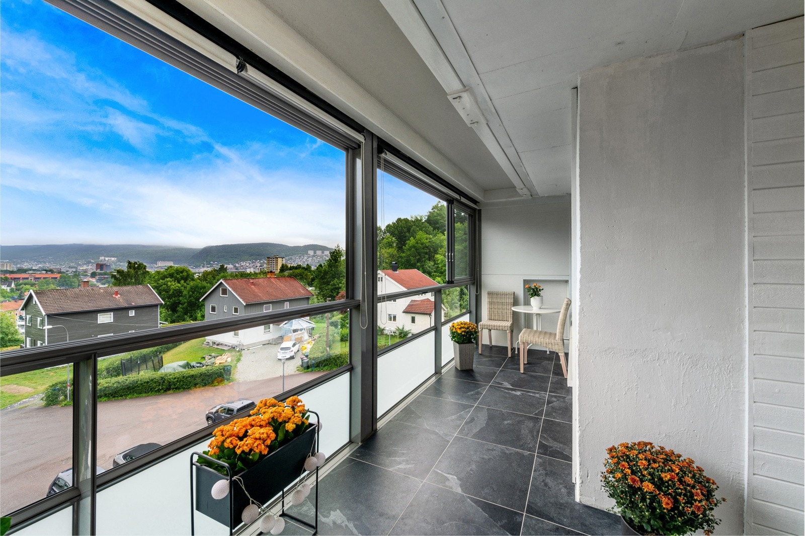 Balkongen er i 2022 flislagt med store, grå fliser og har lysmalte veggflater. Galleribilde