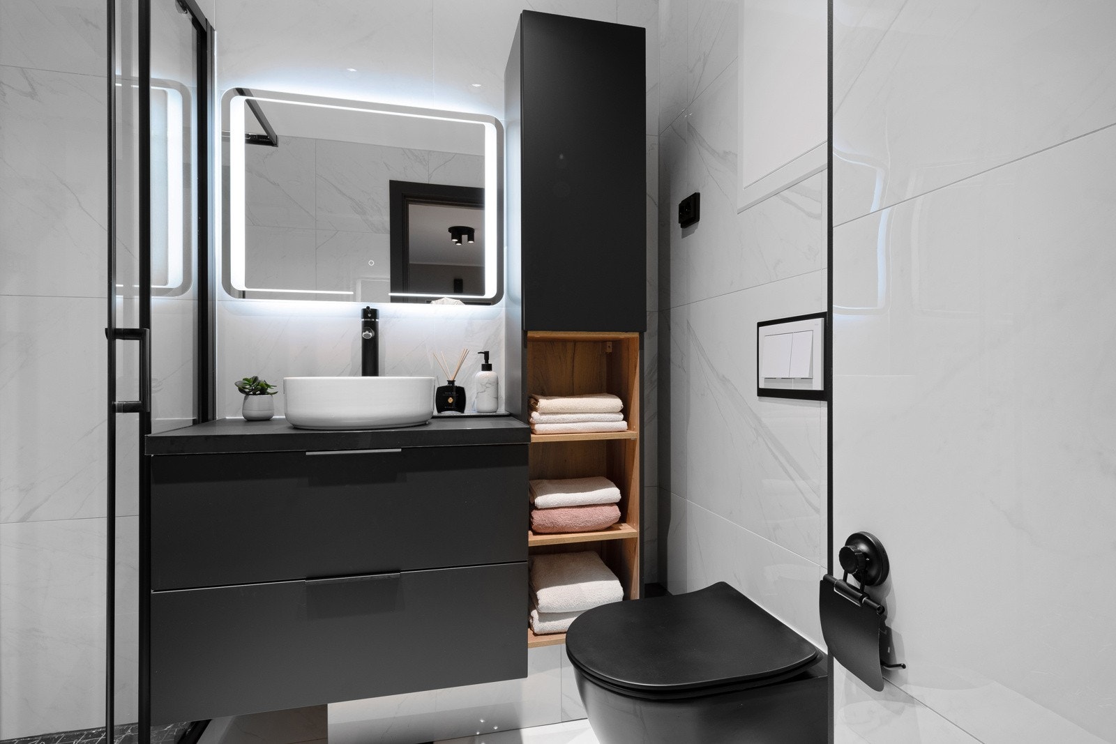 Leiligheten har et kompakt, godt arealutnyttet bad i elegant stil. Rommet ble oppgradert i 2021 og har store, hvite marmorfliser på vegger og gulv. Galleribilde