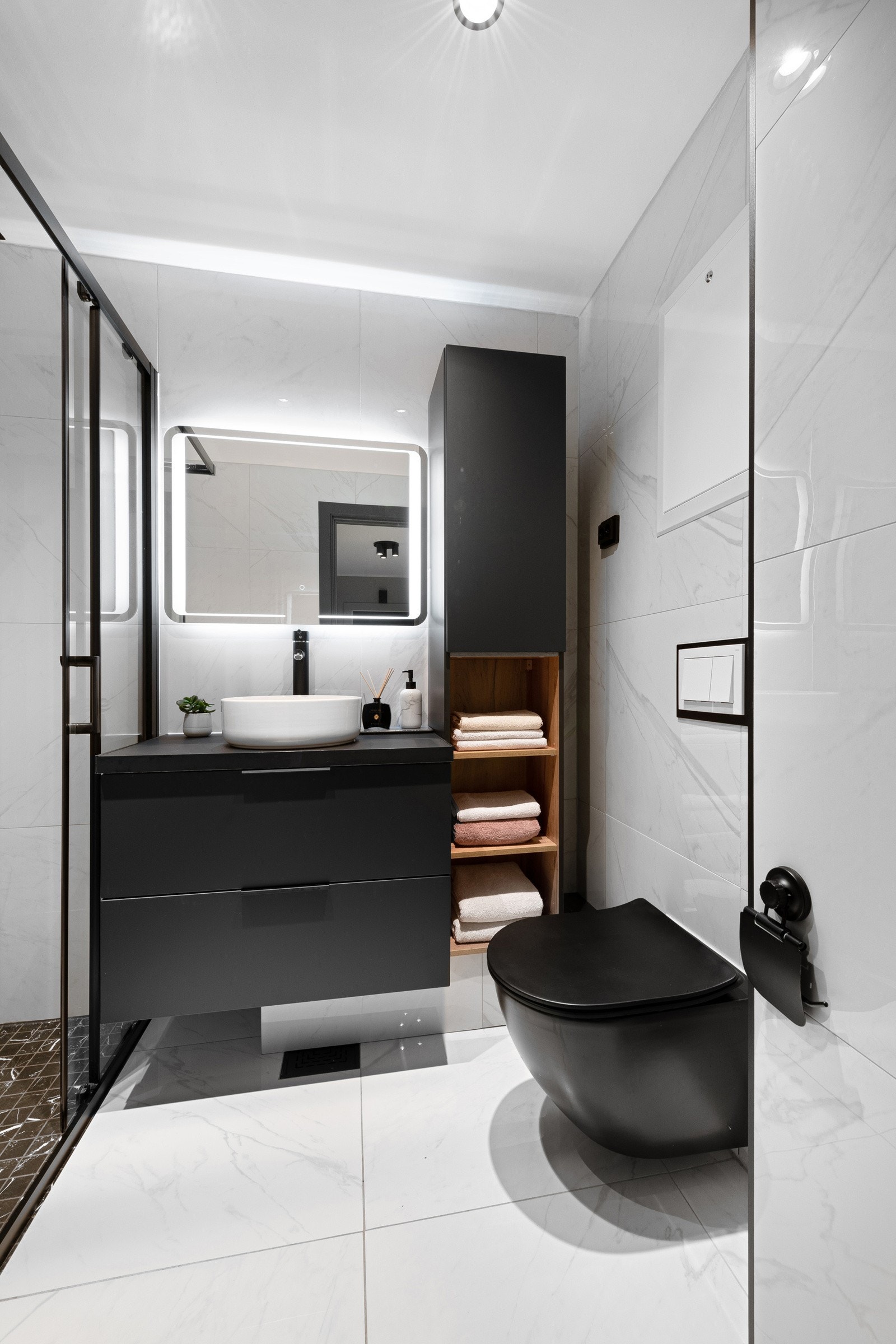 Leiligheten har et kompakt, godt arealutnyttet bad i elegant stil. Rommet ble oppgradert i 2021 og har store, hvite marmorfliser på vegger og gulv. Galleribilde