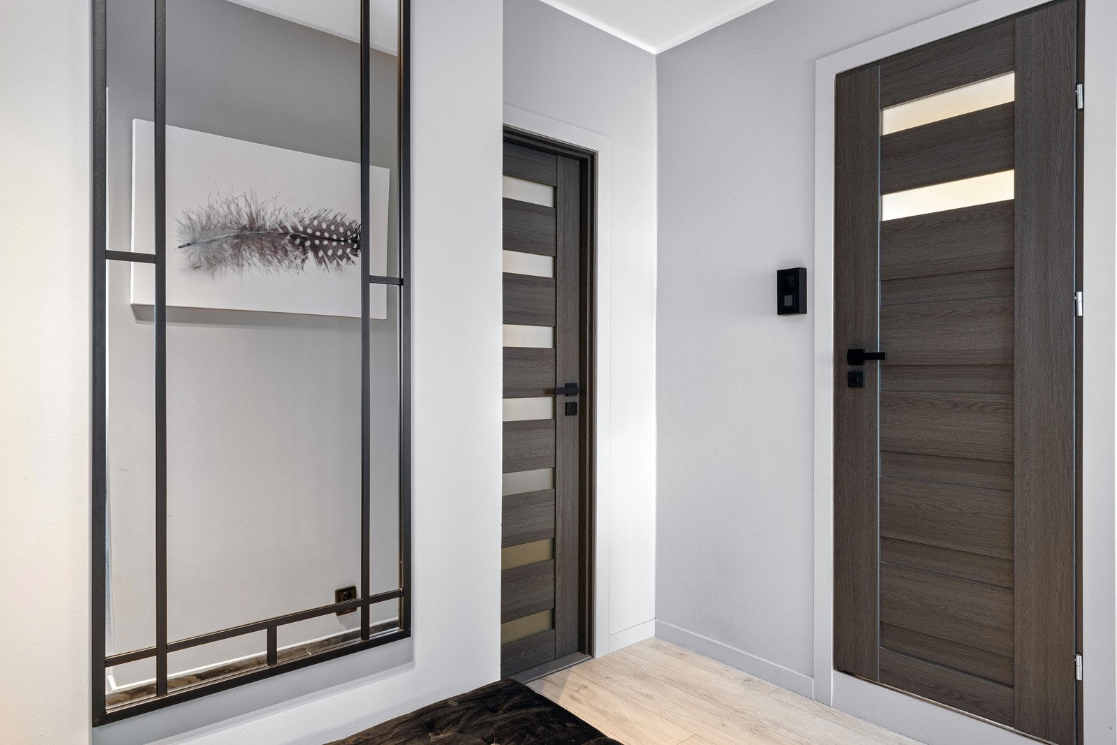 Innerdørene er solide i moderne design, og overflatene for øvrige er slette og malt i lysegrått. Fra vegg til himling er det listefritt. Ved inngangsdøren har leiligheten dørtelefon med åpner. Galleribilde