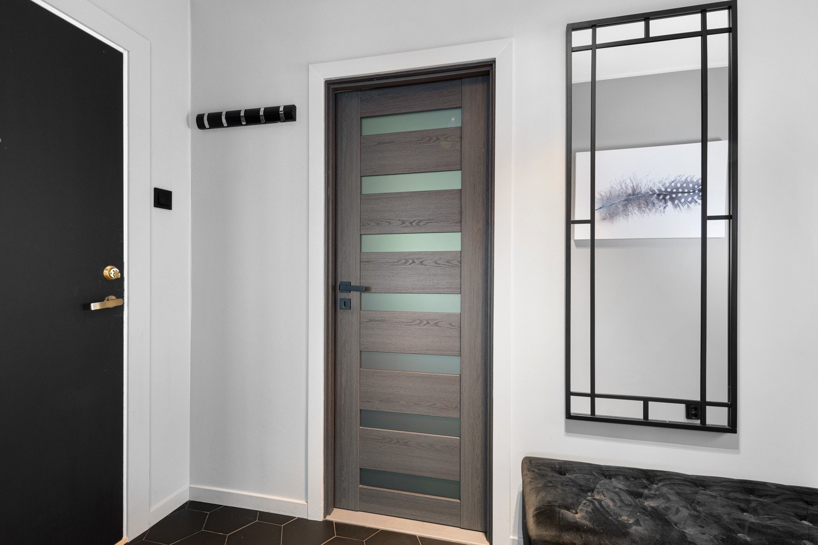 Leiligheten er pusset opp og oppgradert i 2021/2022 og entreen gir en smakebit på stilen. Gulvet har et flislagt felt med sorte heksagonfliser nærmest inngangsdøren og enstavs laminat videre inn i gangen og stuen. Galleribilde