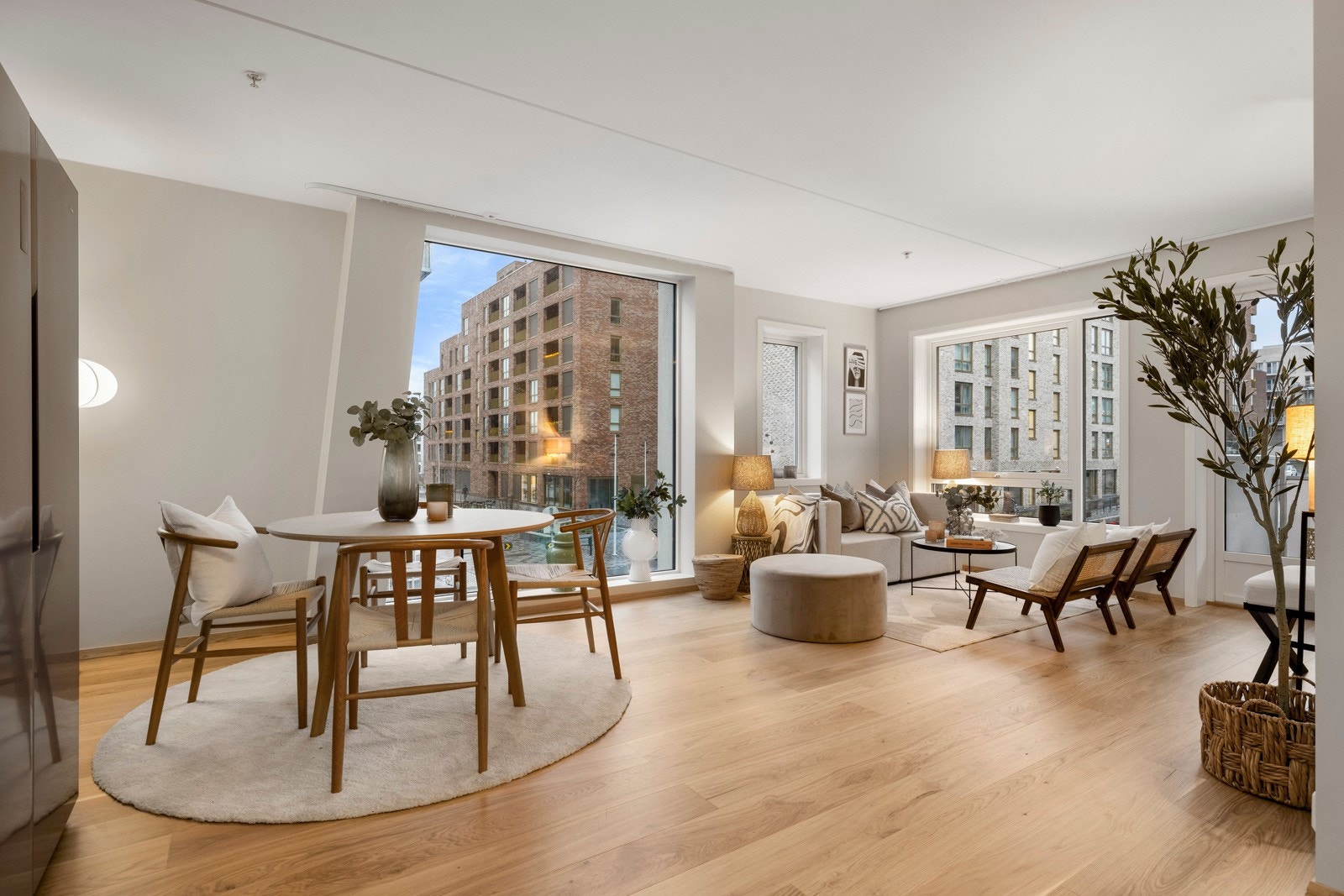 Leilighetens åpne stue-/kjøkkenløsning gir en luftig og sosial atmosfære, hvor store vinduer slipper inn rikelig med naturlig lys. Galleribilde