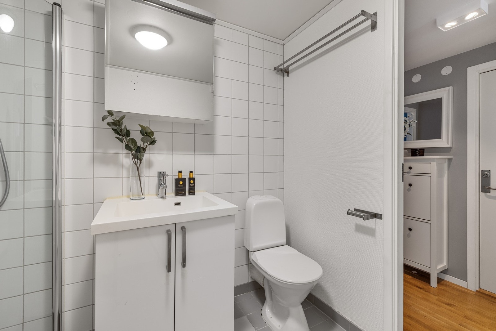 Badet er utstyrt med servantskap med glatte fronter, heldekkende servant, gulvmontert klosett, dusjhjørne med svingdører, samt termostatstyrt blandebatteri. Det er opplegg for vaskemaskin. Galleribilde