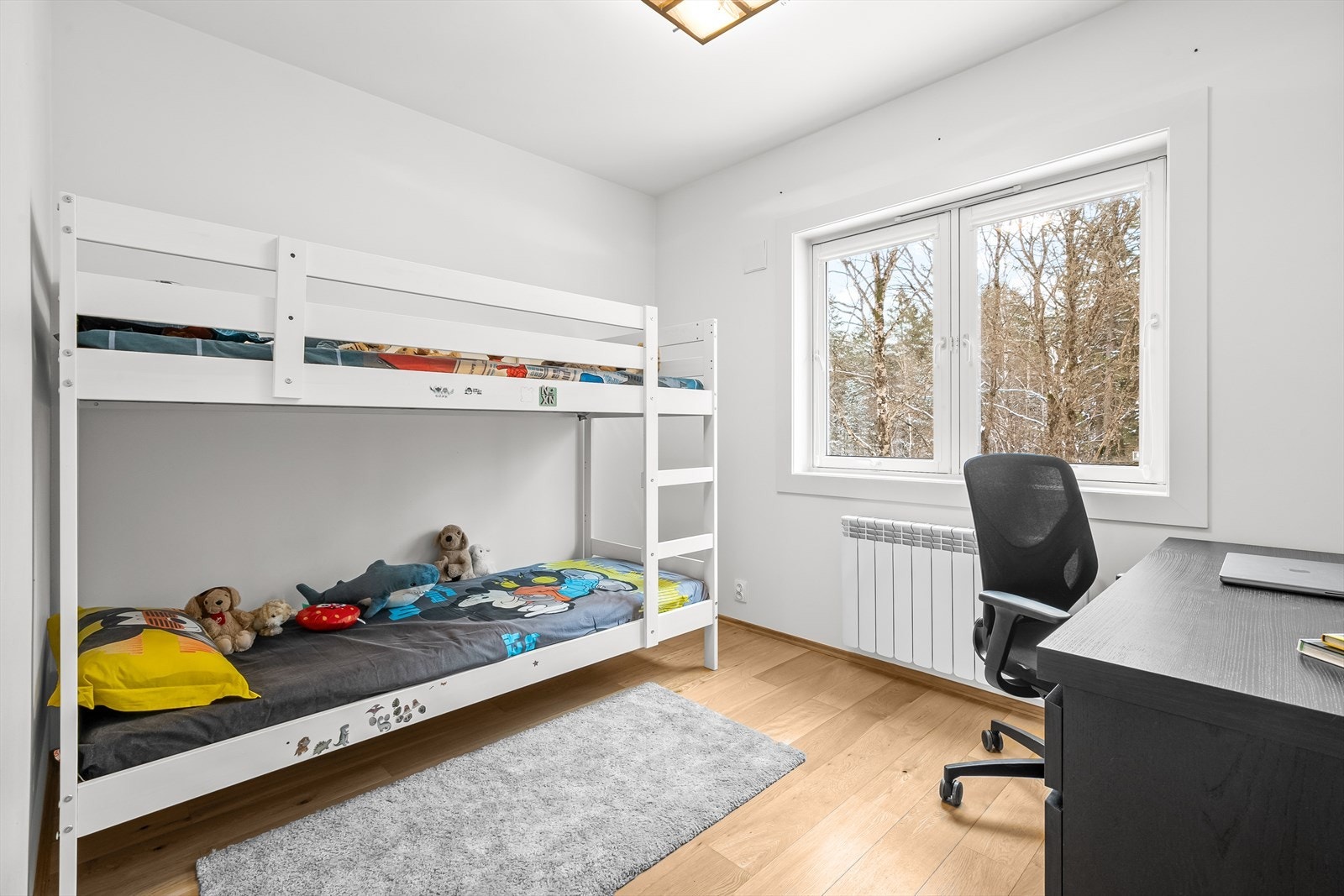 Soverom nummer to passer perfekt som barnerom, gjesterom og/eller hjemmekontor. Begge soverommene vender mot rolig omgivelser og har et hyggelig utsyn til skogsomårde. Galleribilde