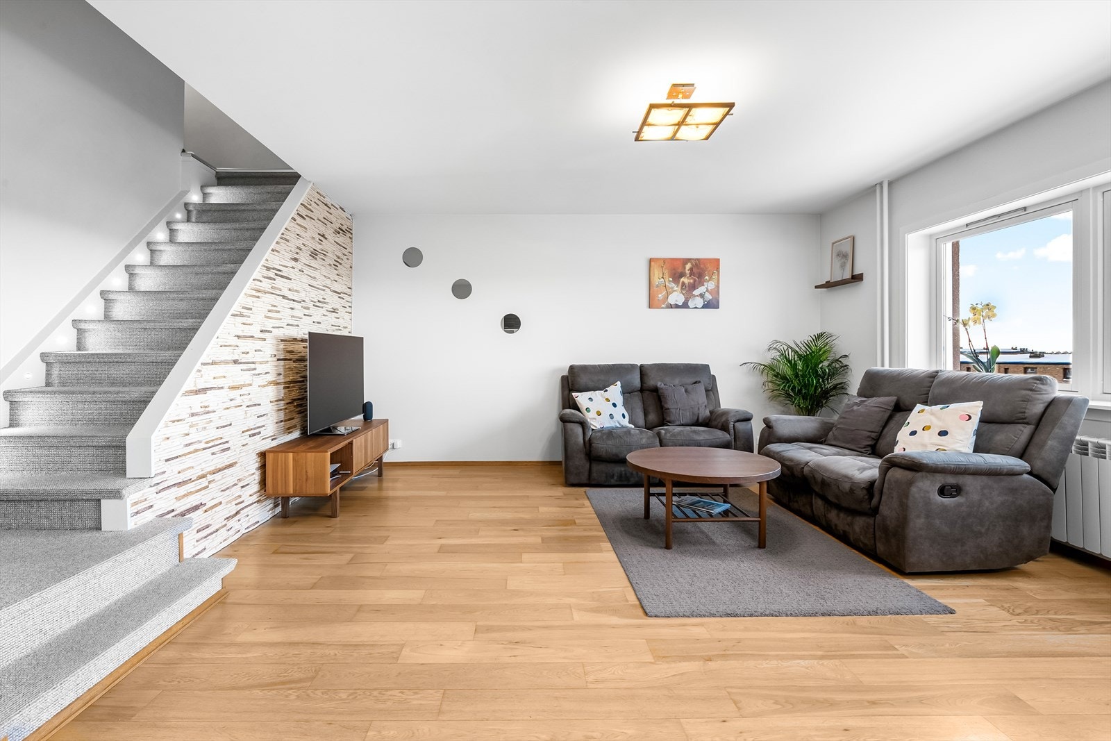 Leiligheten har en lys og tiltalende stue med store vindusflater som gir rommet godt med naturlig lys og en hyggelig utsikt. Galleribilde