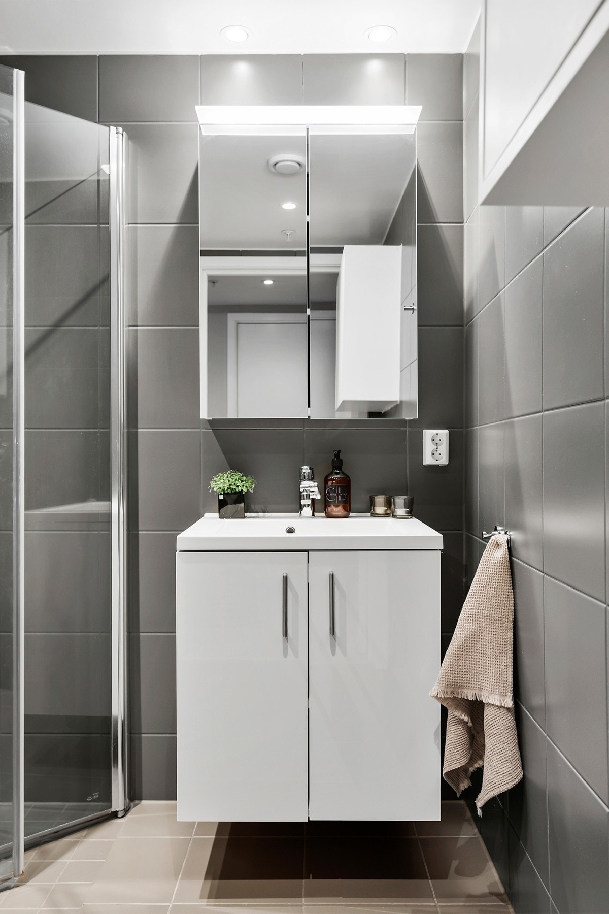 Badet består av inn og utadslående dusjvegger, servant med underskap, speil med overlys, vegghengt klosset og opplegg for vaskemaskin. Galleribilde