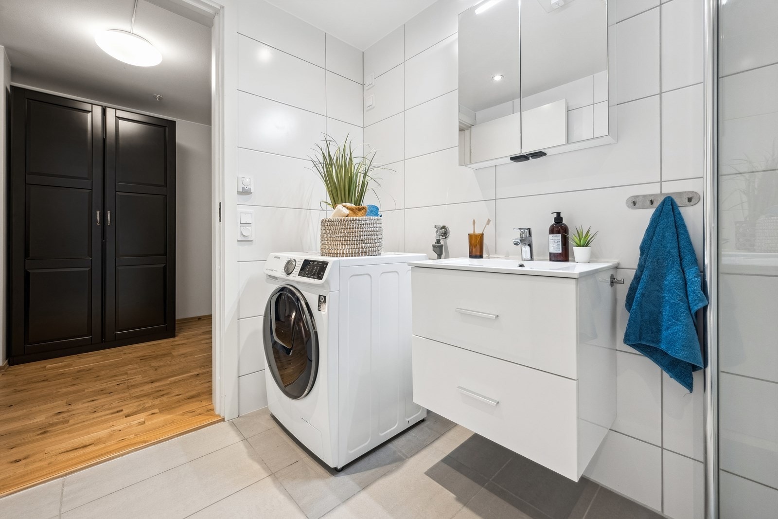 Badet har innredning med servant, dusjhjørne, toalett og opplegg for vaskemaskin. Galleribilde