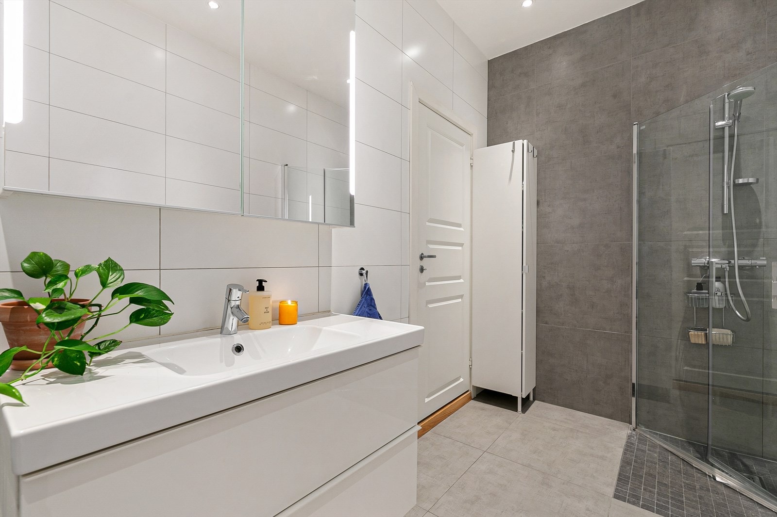 Her får dere alt dere trenger med veggmonterte dusjdører, servant med underskap, speilskap med lys, opplegg for vaskemaskin og veggmontert wc. Dette er virkelig et herlig rom å starte dagen i! Galleribilde