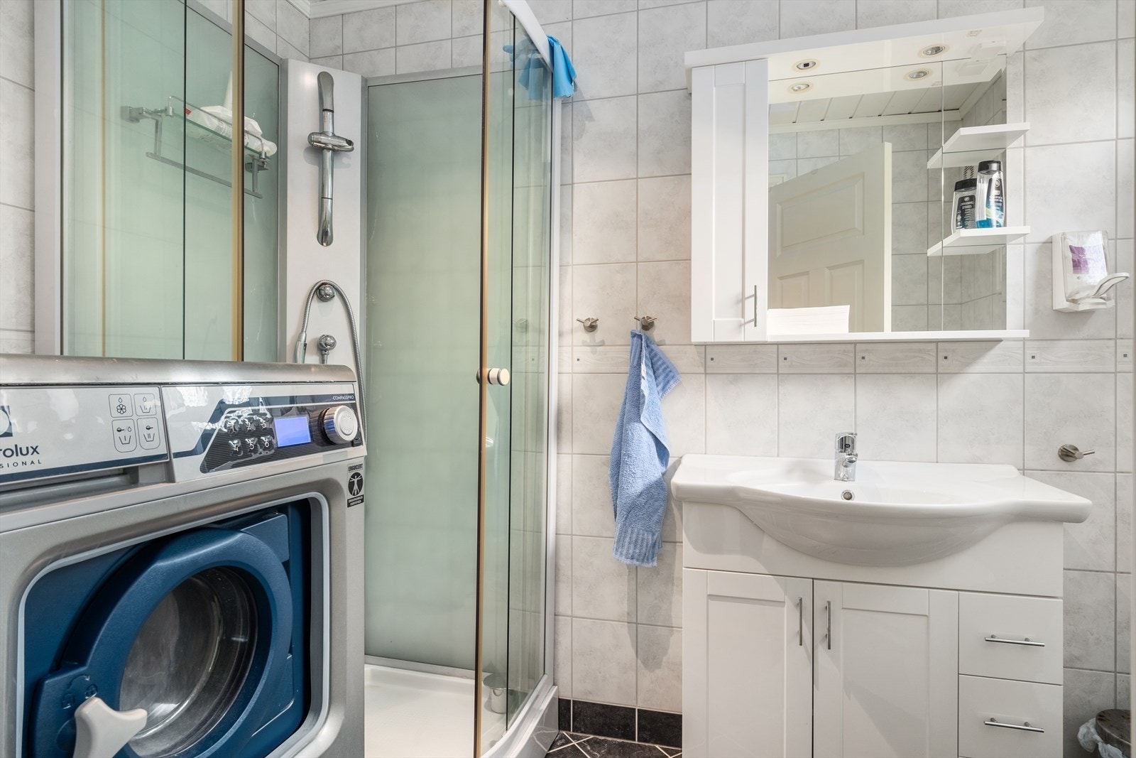Badet er utstyrt med dusjkabinett, toalett og nedfelt servant. Opplegg til vaskemaskin Galleribilde