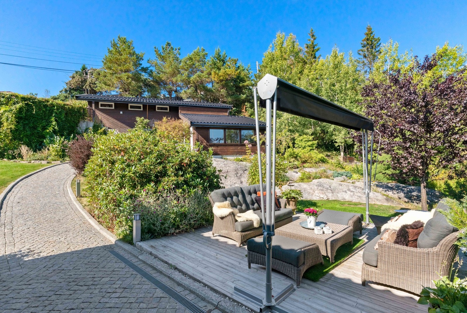 Fra innkjørselen/garasjen er det lagt varmekabler i "stien" ned til boligens inngangsparti. Stien er laget med belegningsstein med tilhørende lysstolper. Galleribilde