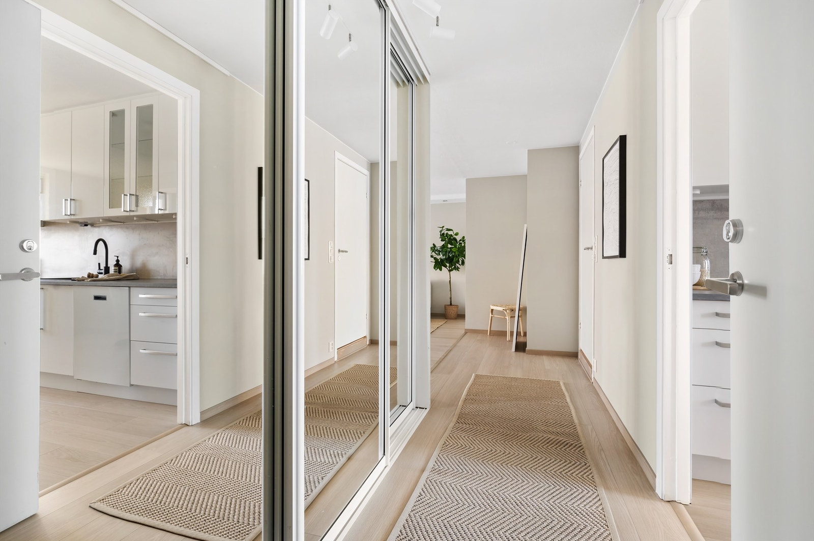 Leilighetens entré er lys og innbydende og gir et godt førsteinntrykk av boligen. Det god oppbevaringsplass i en romslig skyvedørsgarderobe med praktiske speilfronter. Galleribilde