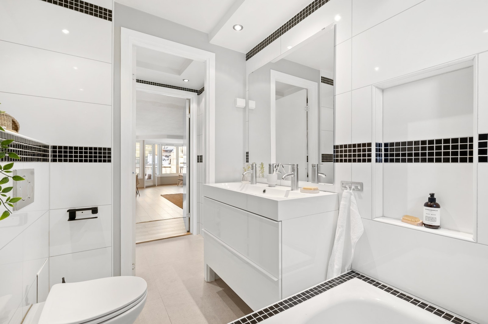 Badet er innredet med vegghengt servantinnredning med skuffer og heldekkende servant. Over servanten er det speil og stikkontakter. Galleribilde