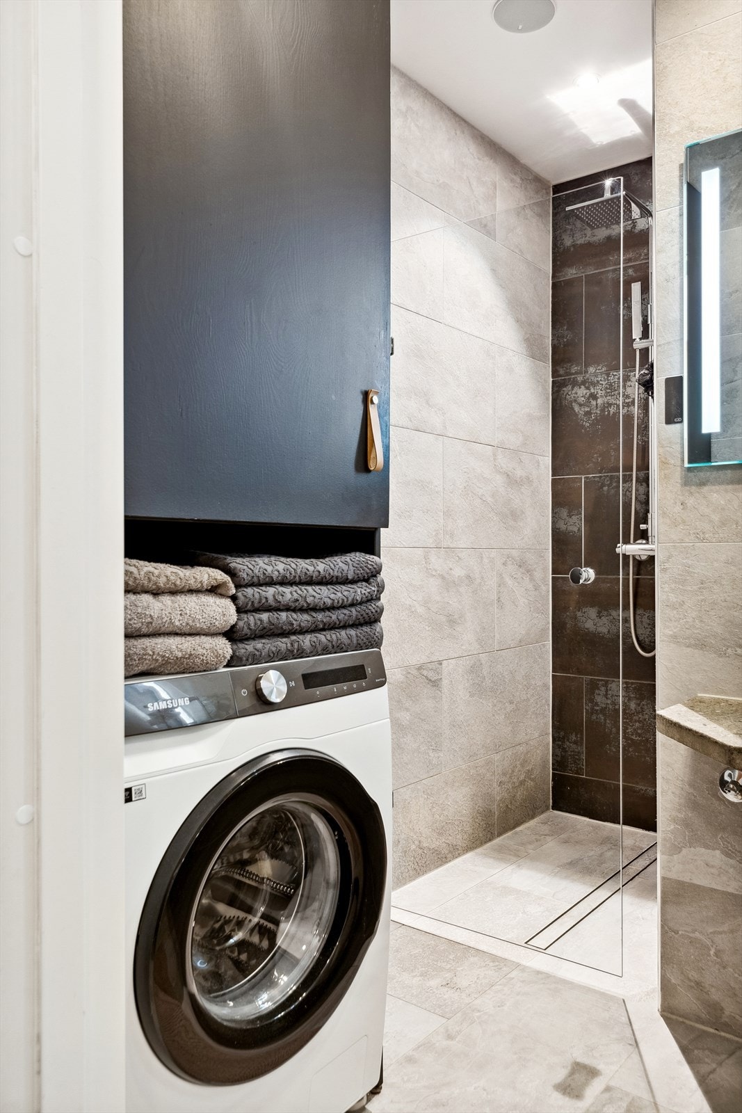 Badet er utstyrt med servant, veggmontert wc, innfellbare dusjdører, opplegg for vaskemaskin, rørfordelingsskap og mekanisk avtrekk. Galleribilde