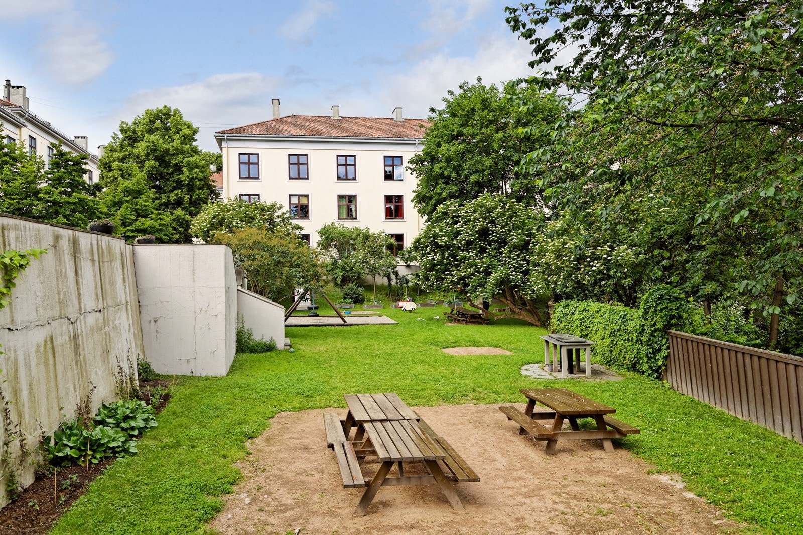 Bakgården er opparbeidet med flere prydbusker, beplantning og sittegrupper Galleribilde