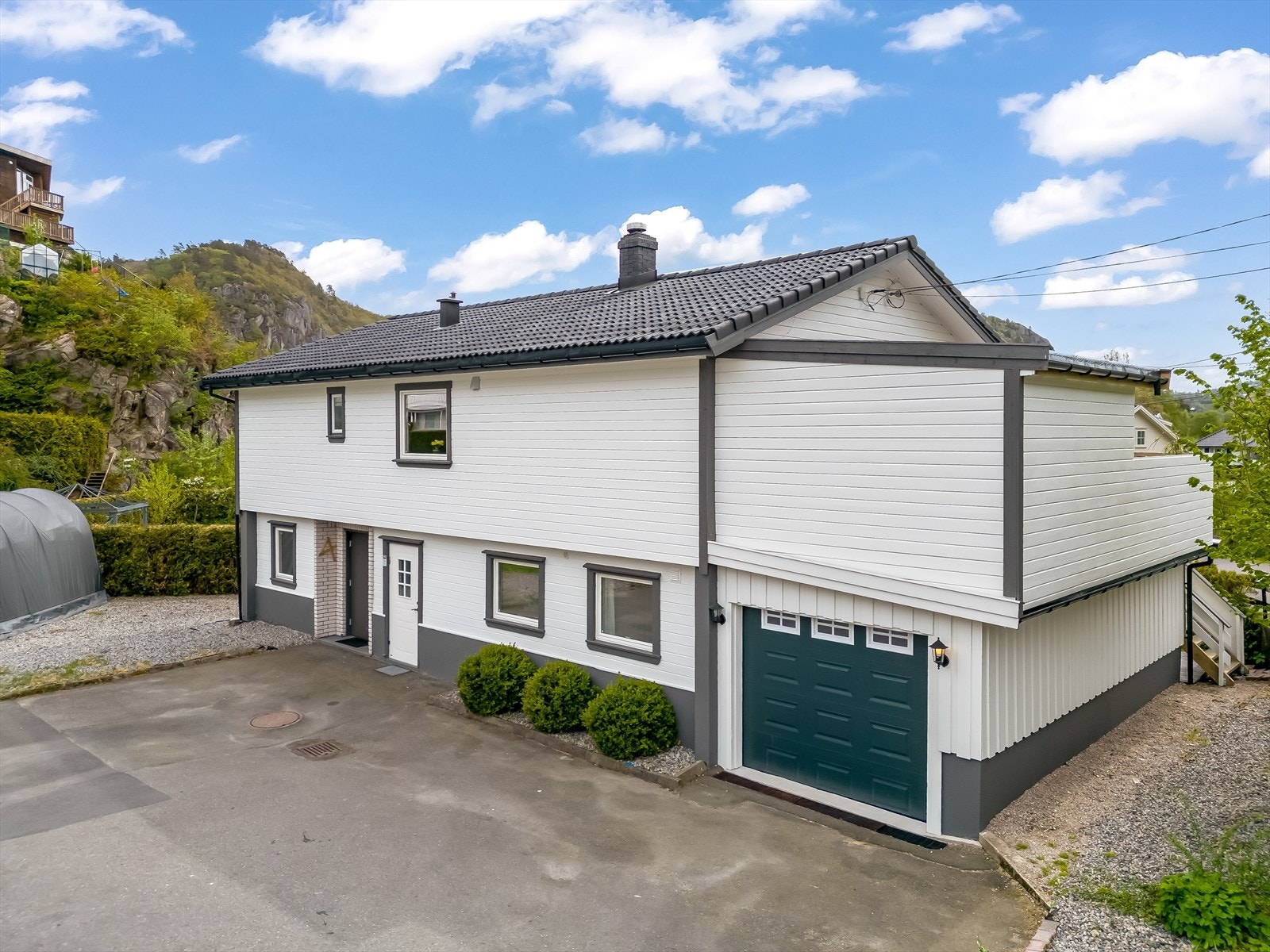 Bakside med garasje og inngang bolig. Galleribilde