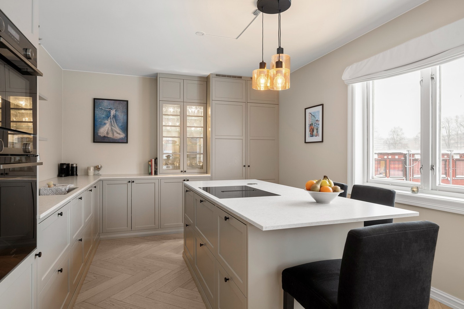 Stor kjøkkenøy med bardiskløsning, ekstra arbeids- og oppbevaringsplass, induksjonstopp med integrert ventilator og Twist stikkontakt med to uttak. Galleribilde