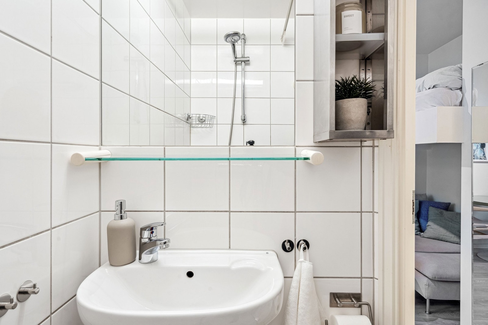 Utstyrt med vegghengt speil, klosett, servant og praktisk oppbevaringshylle. Galleribilde