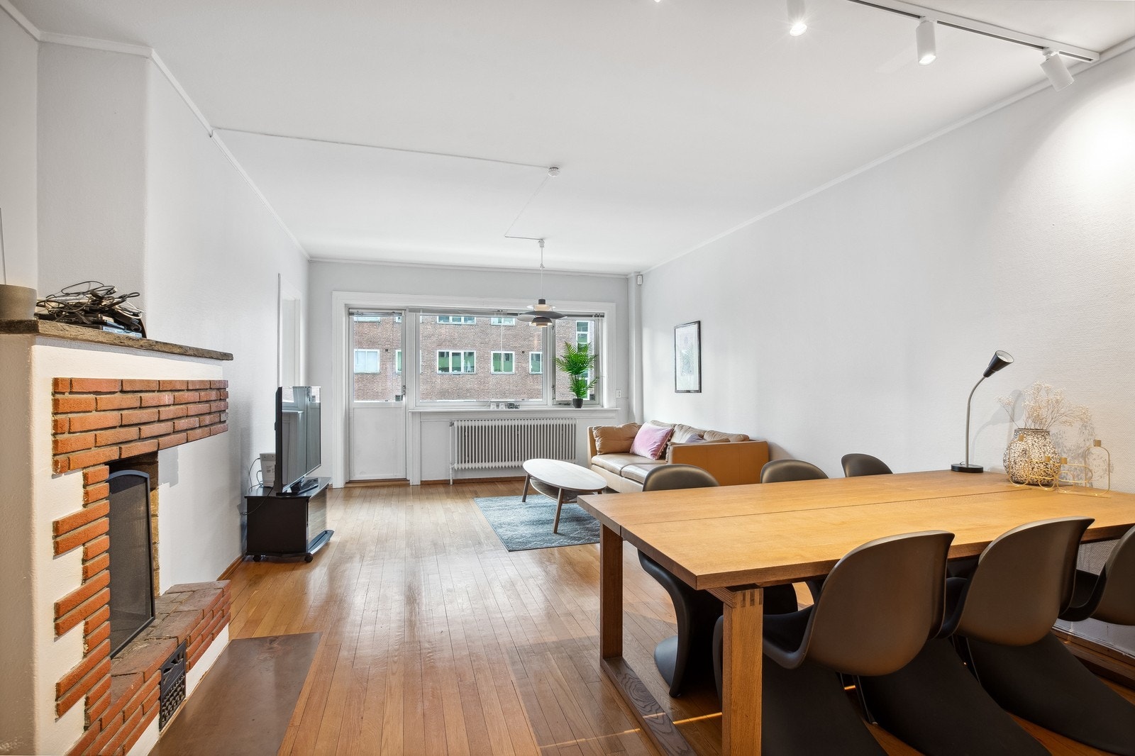 Romslig stue med utgang til balkong og plass til både sofa og spisebord. Galleribilde