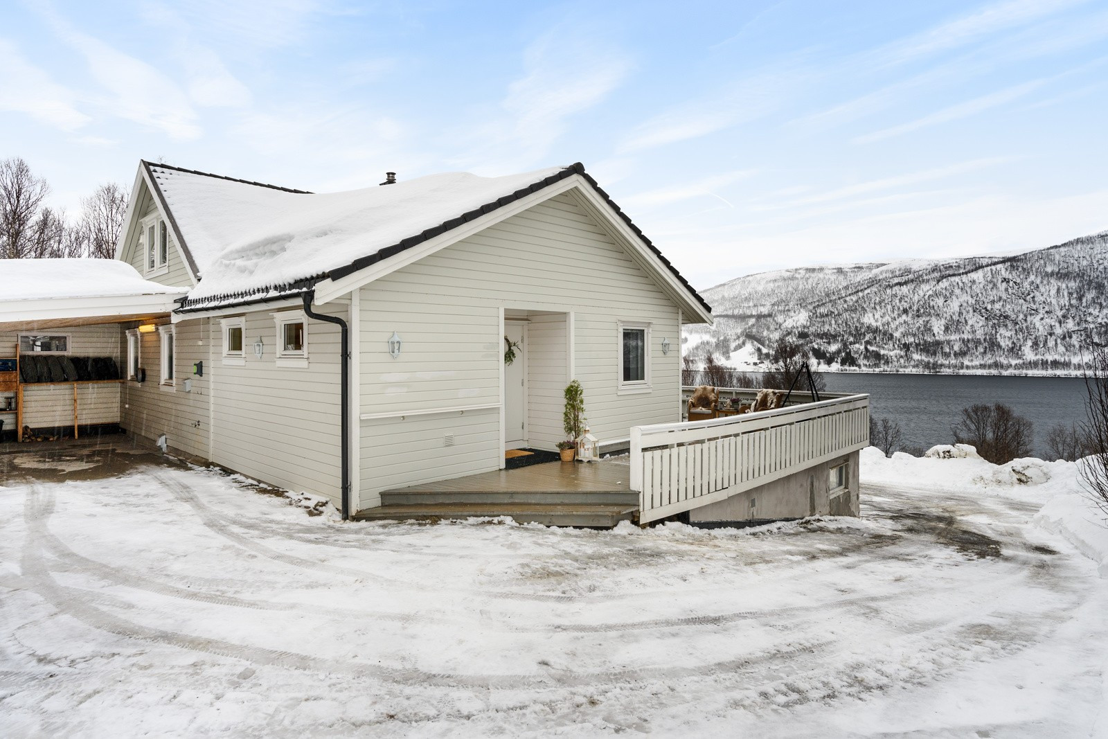 Fra carporten går du rundt til verandaen og inngangsdøra.