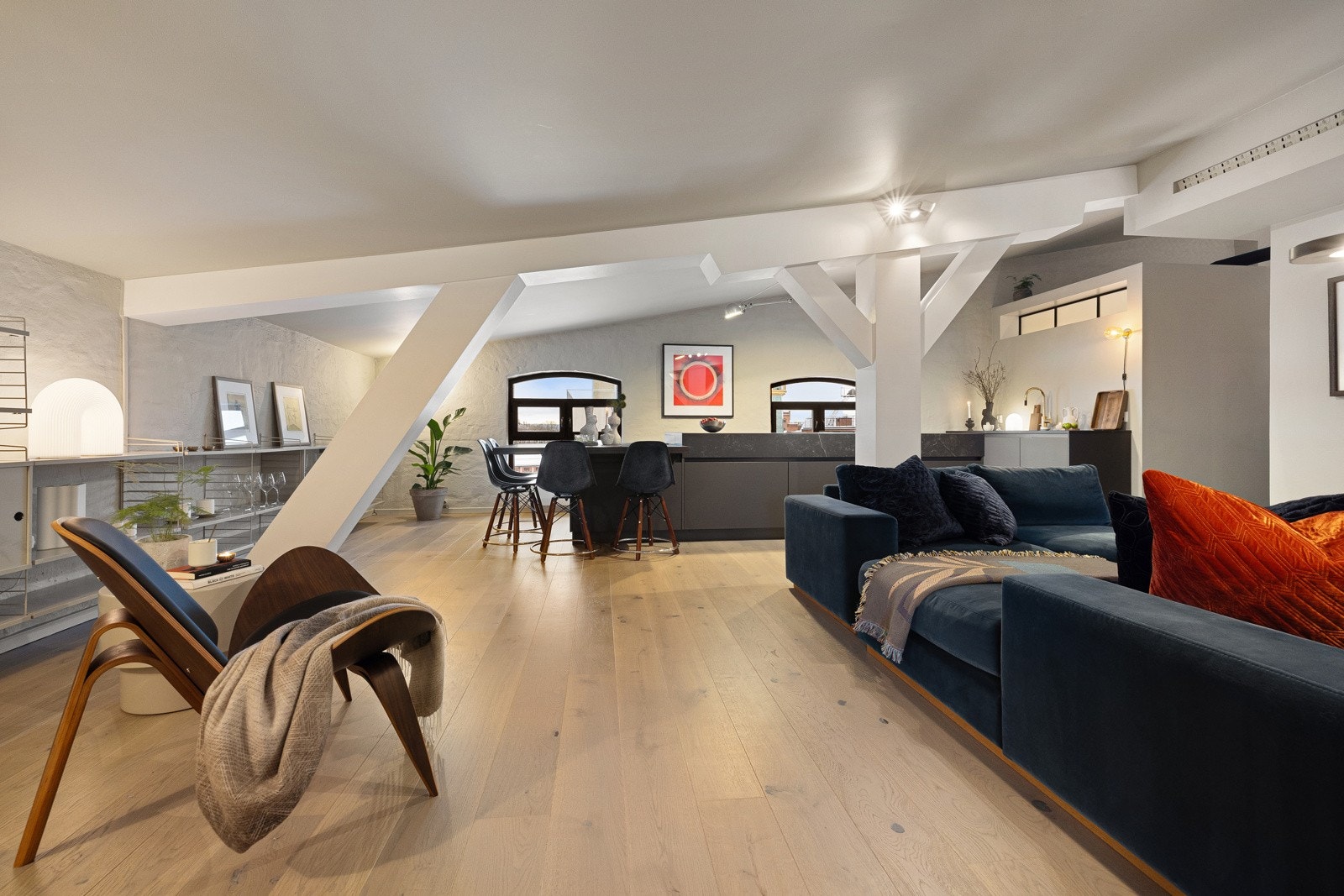 Oppholdsrommet er lyst og unikt med kraftige trebjelker i tak og synlig murvegg Galleribilde