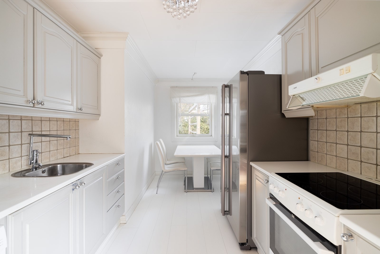 Lyst og romslig kjøkken tilliggende stuen, med kjøkkeninnredning av eldre standard. Profilerte fronter er malt opp i senere tid. Galleribilde