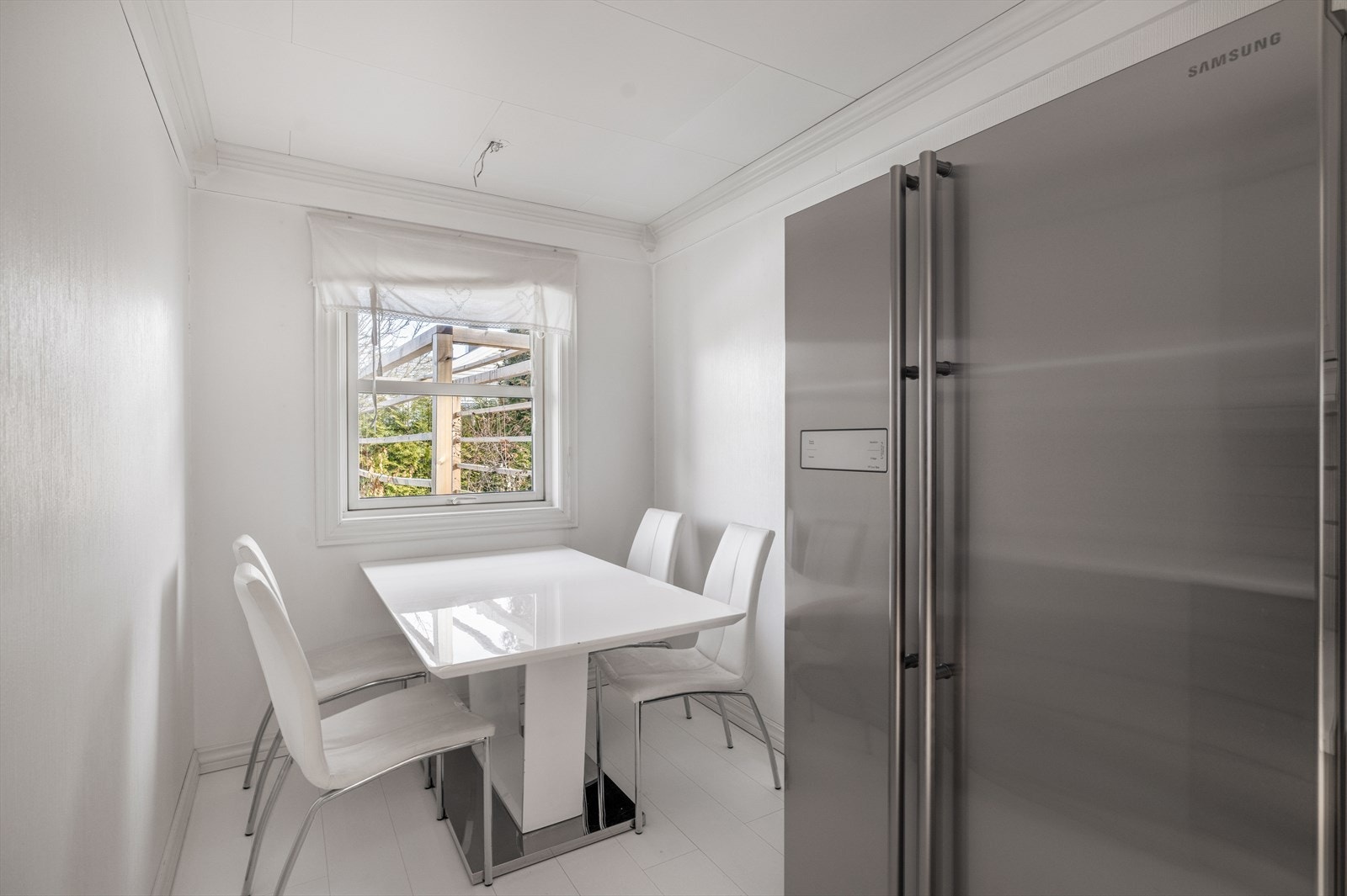 Kjøkkenet har fin spiseplass ved kjøkkenvindu. Det er flis på vegg over laminat benkeplate med nedfelt oppvaskkum. Galleribilde