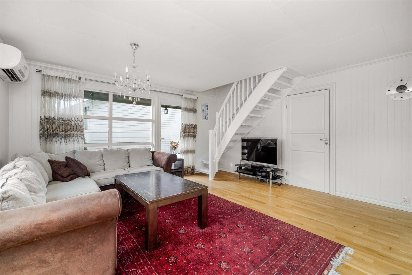 Romslig stue med lyse overflater og store vindusflater, samt utgang til vestvendt terrassedel via enkel terrassedør. Galleribilde