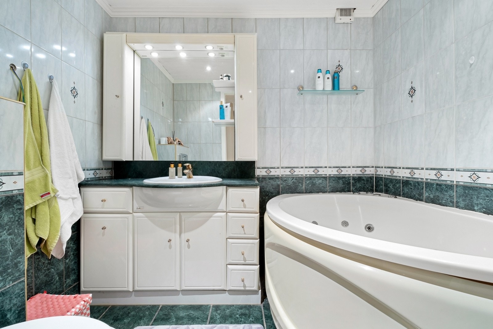 Eldre flislagt bad i boligens 1. etasje, pusset opp i 2004 ifølge eier. Innredningen består av klassisk servantmøblement, speil, toalett, samt et stort hjørnebadekar m/dusjløsning. Galleribilde