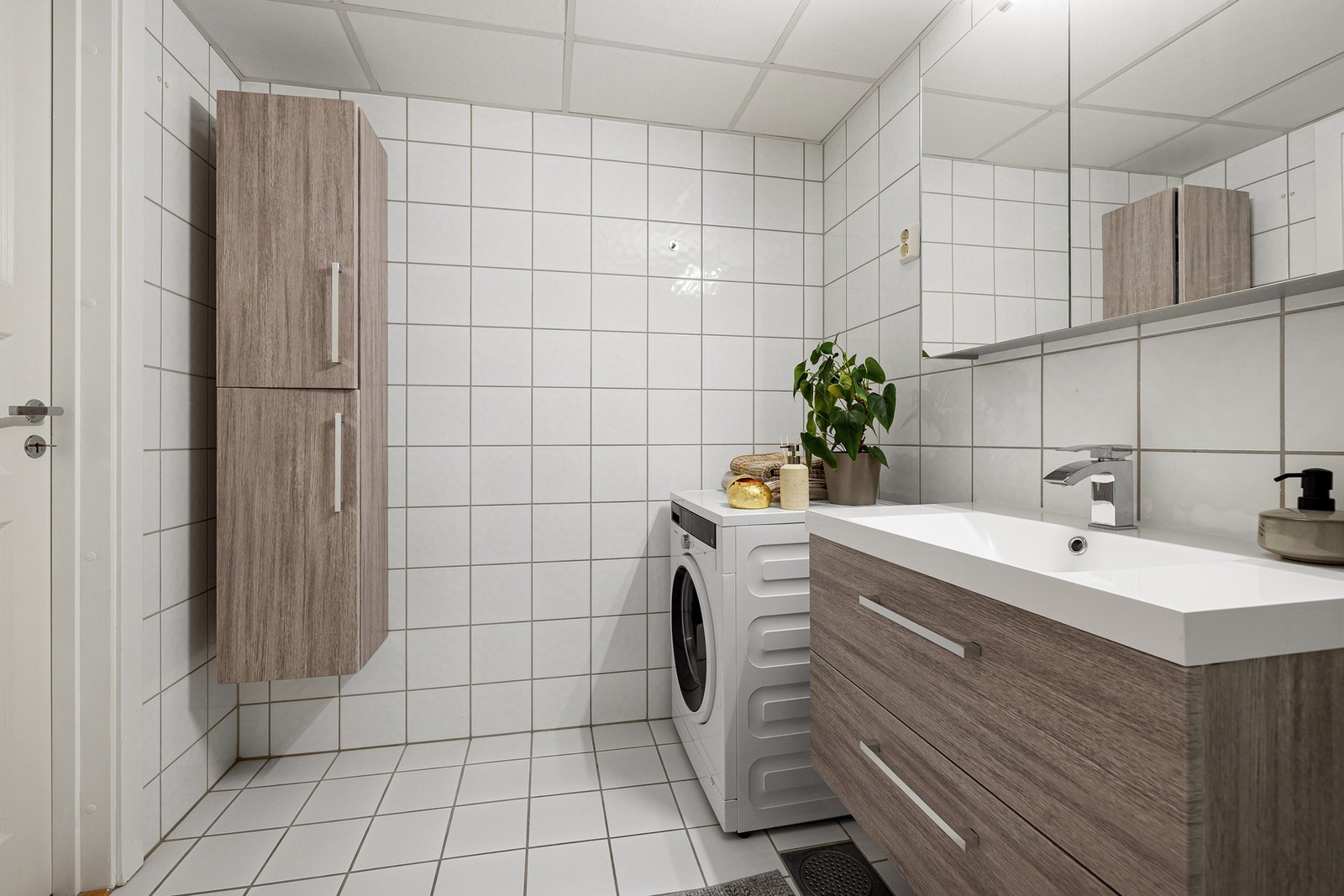 Badet er innredet med baderomsbenk, speilskap, veggmontert høyskap, toalett, samt dusjhjørne med regn- og hånddusj. Galleribilde