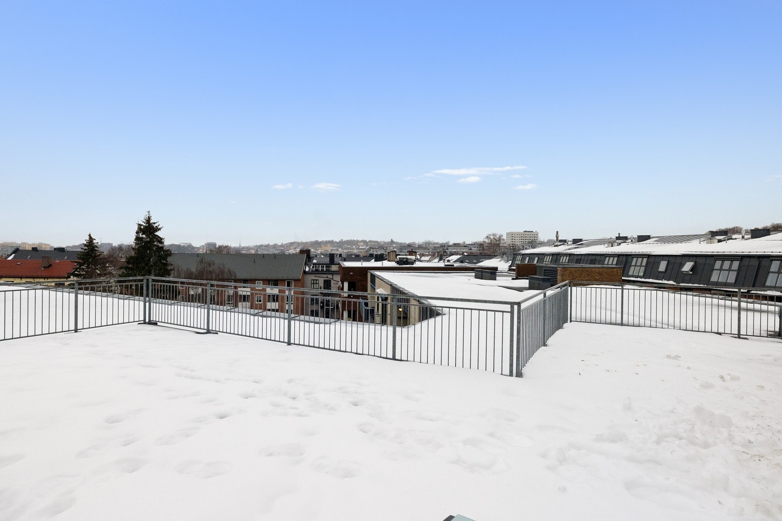 Stor felles takterrasse med flere sittegrupper og fantastisk utsikt over byen. Galleribilde