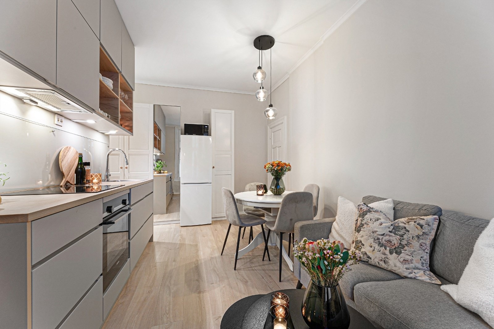 Lys, innbydende og moderne kjøkken/spise/stue løsning. Ved kjøleskapet ser man at det er god plass til ekstra garderobeskap. Entrè/stue/kjøkken har laminatgulv m/varmefolie. Galleribilde