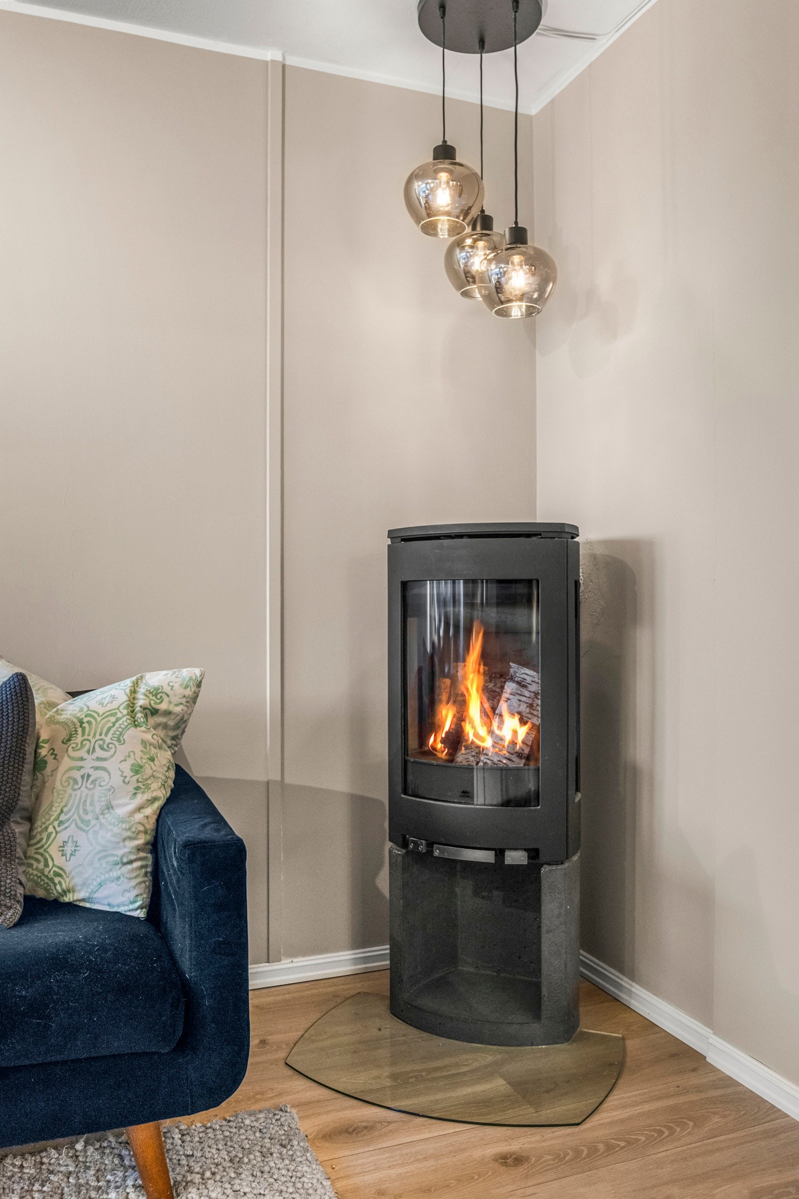 I hjørnet er det en moderne peis for både varme og ekstra hygge. Pipene ble rehabilitert i regi av brl. i 2021. Galleribilde