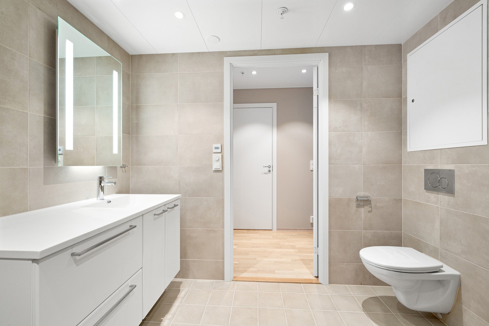 Baderommet er oppgradert til servantkran Grohe New Essence i fargen krom, beige veggflis, beige gulvflis, spyleknapp krom rund og rainshower fra Grohe i krom utførelse. Galleribilde