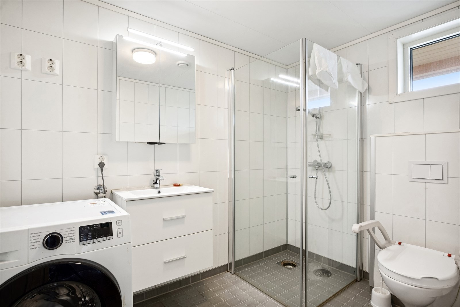 På badet er det dusjhjørne med innfellbare dører og vegghengt toalett som gir et moderne uttrykk. Galleribilde