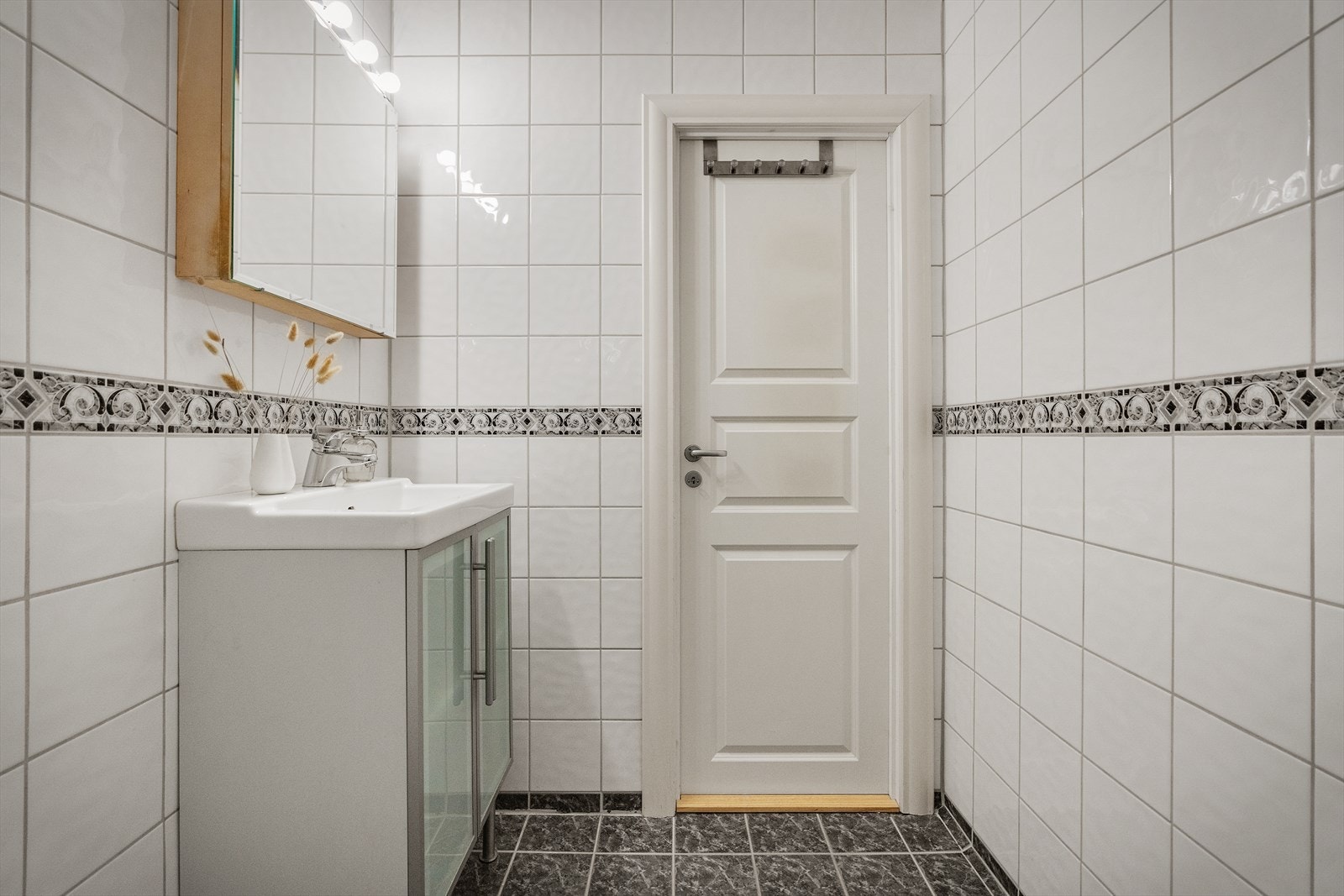 - Badet inneholder toalett, benkeskap med servant, dusjdører i glass og opplegg for vaskemaskin - Galleribilde