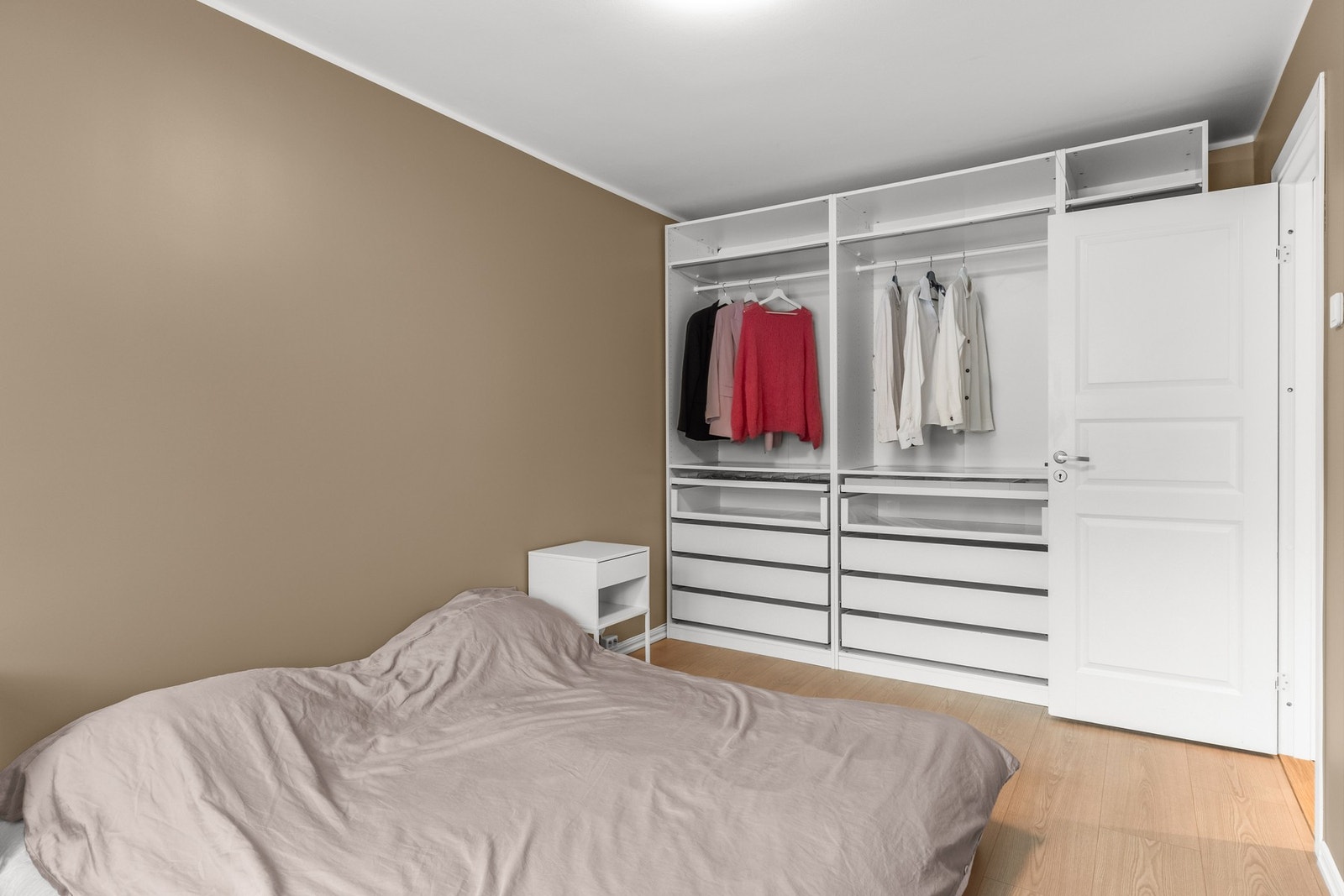 Hovedsoverommet er romslig med garderobeinnredning, tidsriktige farger på veggene og laminatgulv fra oppgraderingen i 2022. Galleribilde