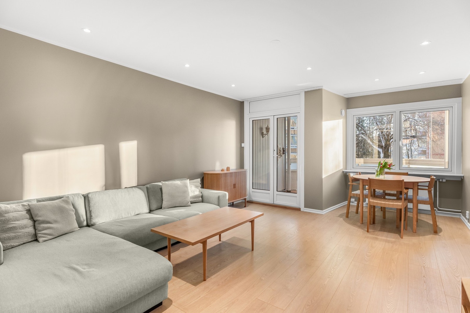 Stuen er et lyst og romslig oppholdsrom. Store vinduer og balkongdør, som ble skiftet ut i 2016, slipper inn rikelig med naturlig lys og gir en luftig atmosfære. Galleribilde