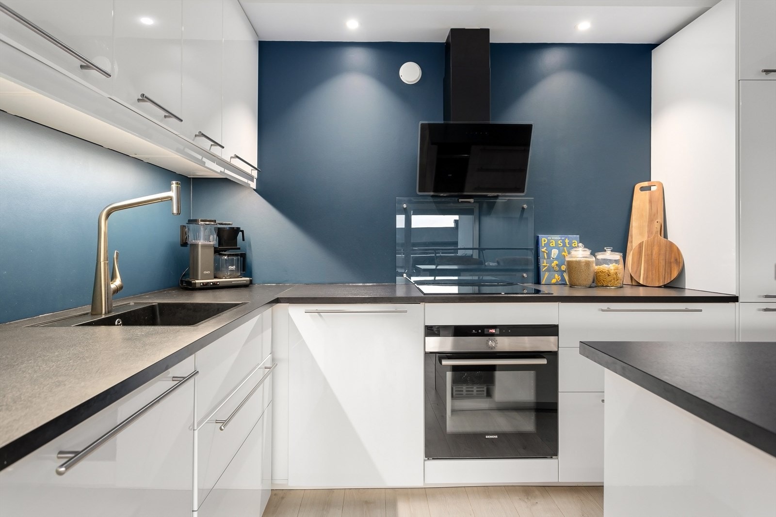 Lekkert åpent kjøkken med glatte fronter og mye skapplass Galleribilde