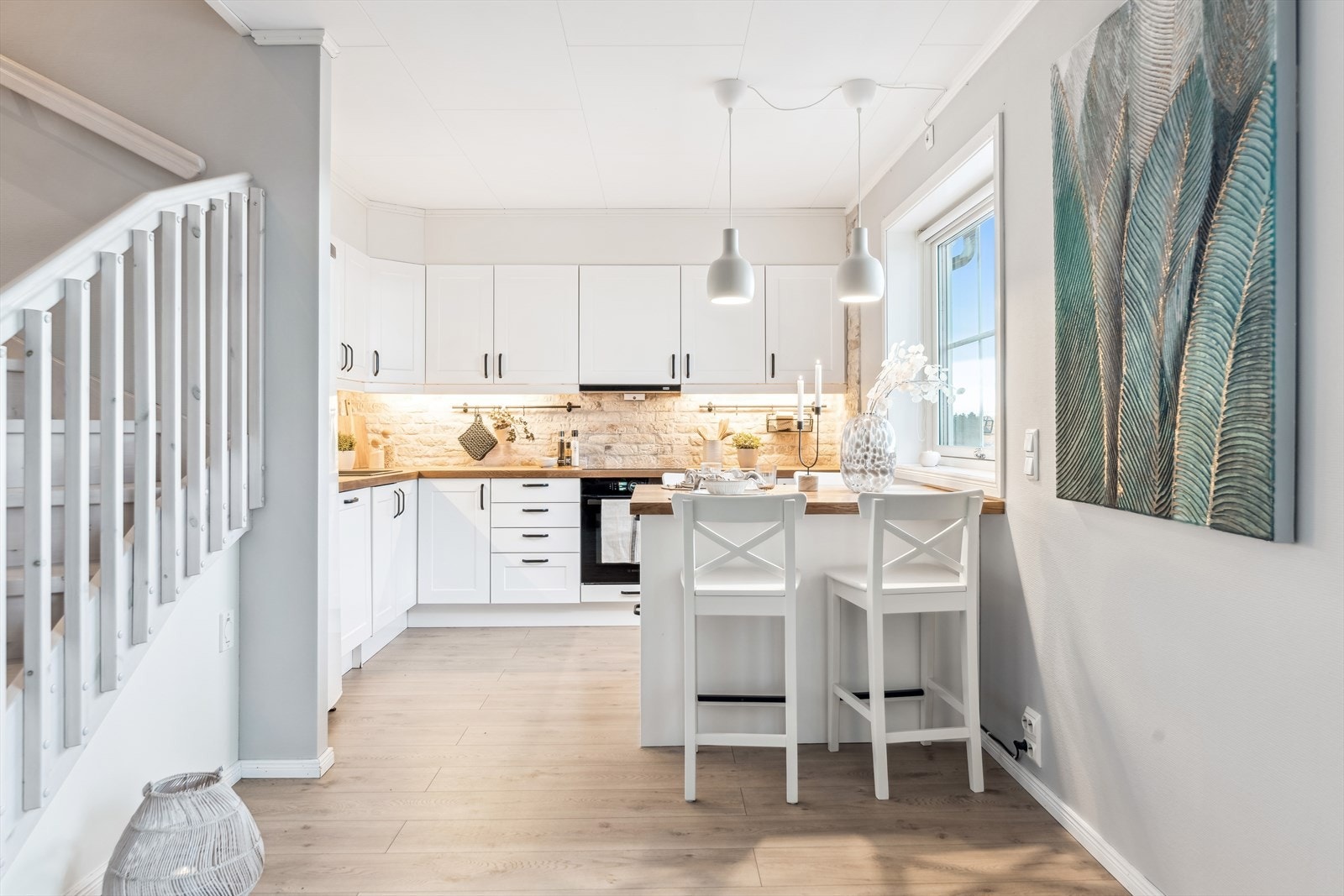 Lekkert kjøkken med heltre benkeplate, flotte fliser over benken og kjøkkenøy Galleribilde