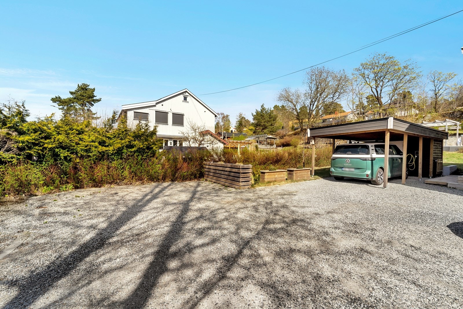 Boligen disponerer utvendig carport på 18 m² og uisolert utebod på 5,4m² som er oppført i 2022. Port ut mot Hellerudveien og gruset felles gårdsplass på eiendommen. Galleribilde