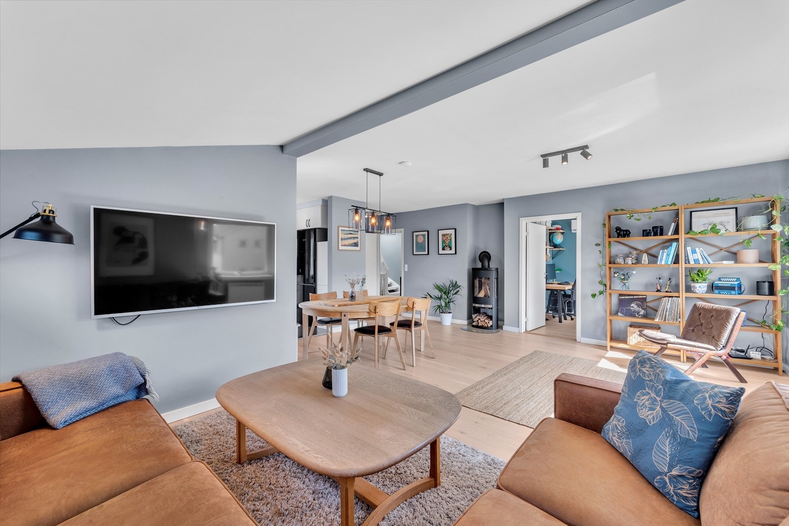 En stor og luftig stue med parkett på gulv, malte slette vegger og malt tak. Stuen har god plass til sofagruppe og spisemøblement og det er montert en nyere peis ovn. Galleribilde