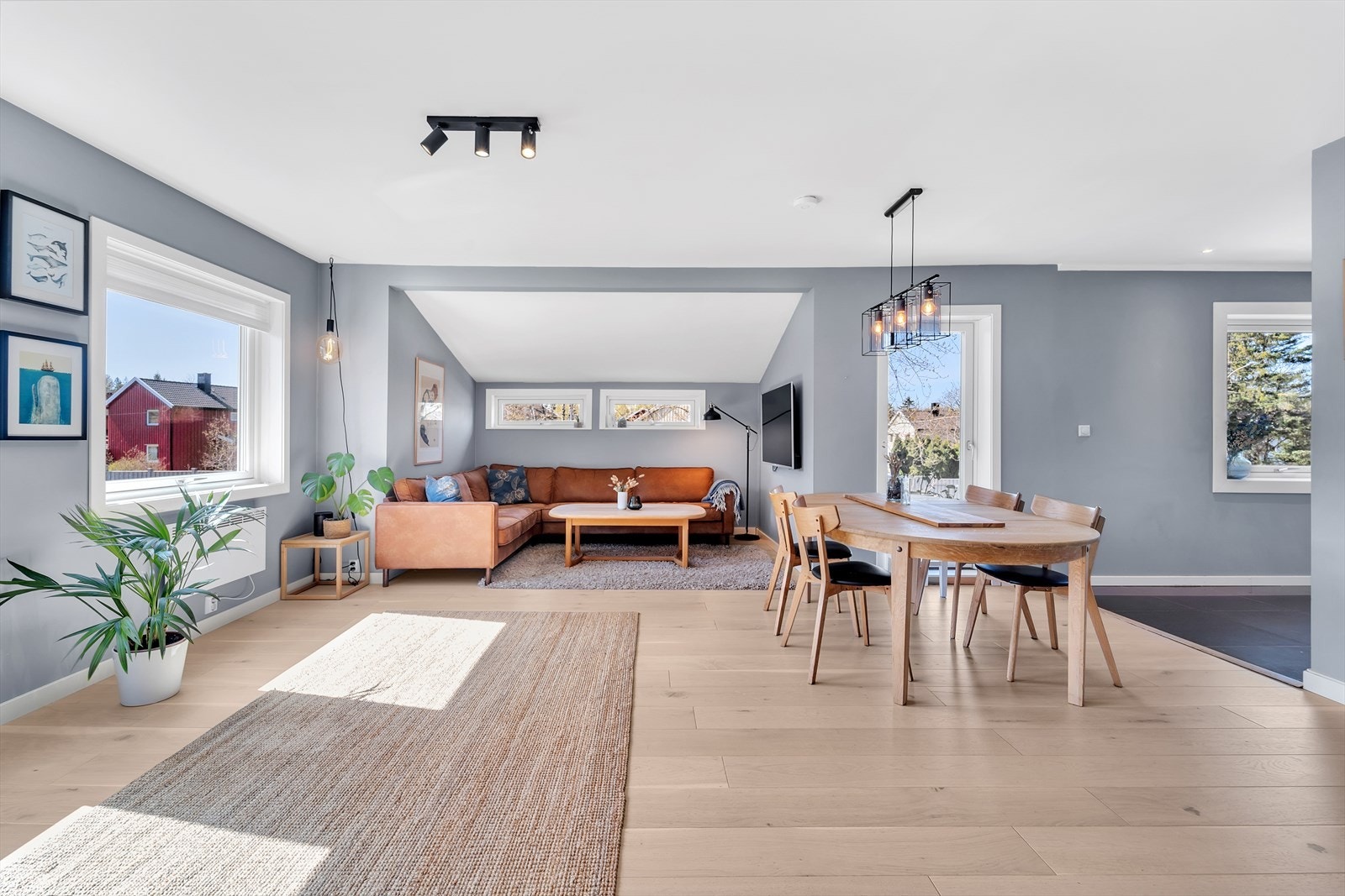 En stor og luftig stue med parkett på gulv, malte slette vegger og malt tak. Stuen har god plass til sofagruppe og spisemøblement og det er montert en nyere peis ovn. Galleribilde