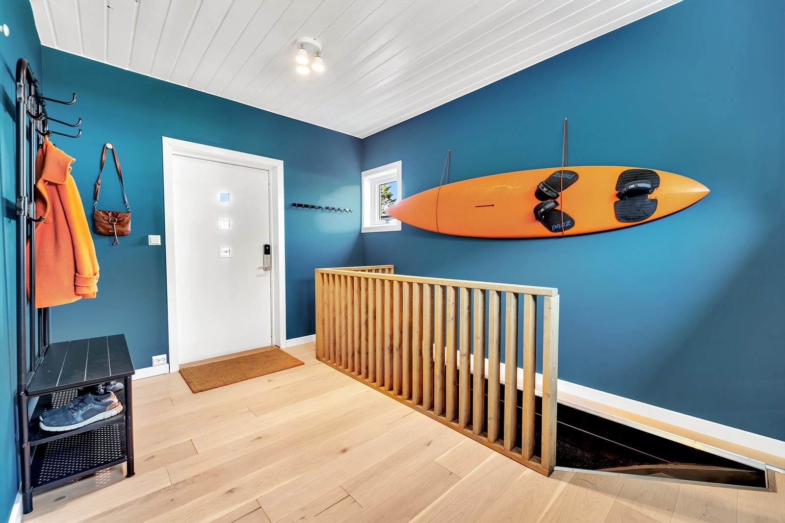 Stor og luftig entré med malte slette vegger, parkett på gulv og malt panel i tak. Galleribilde