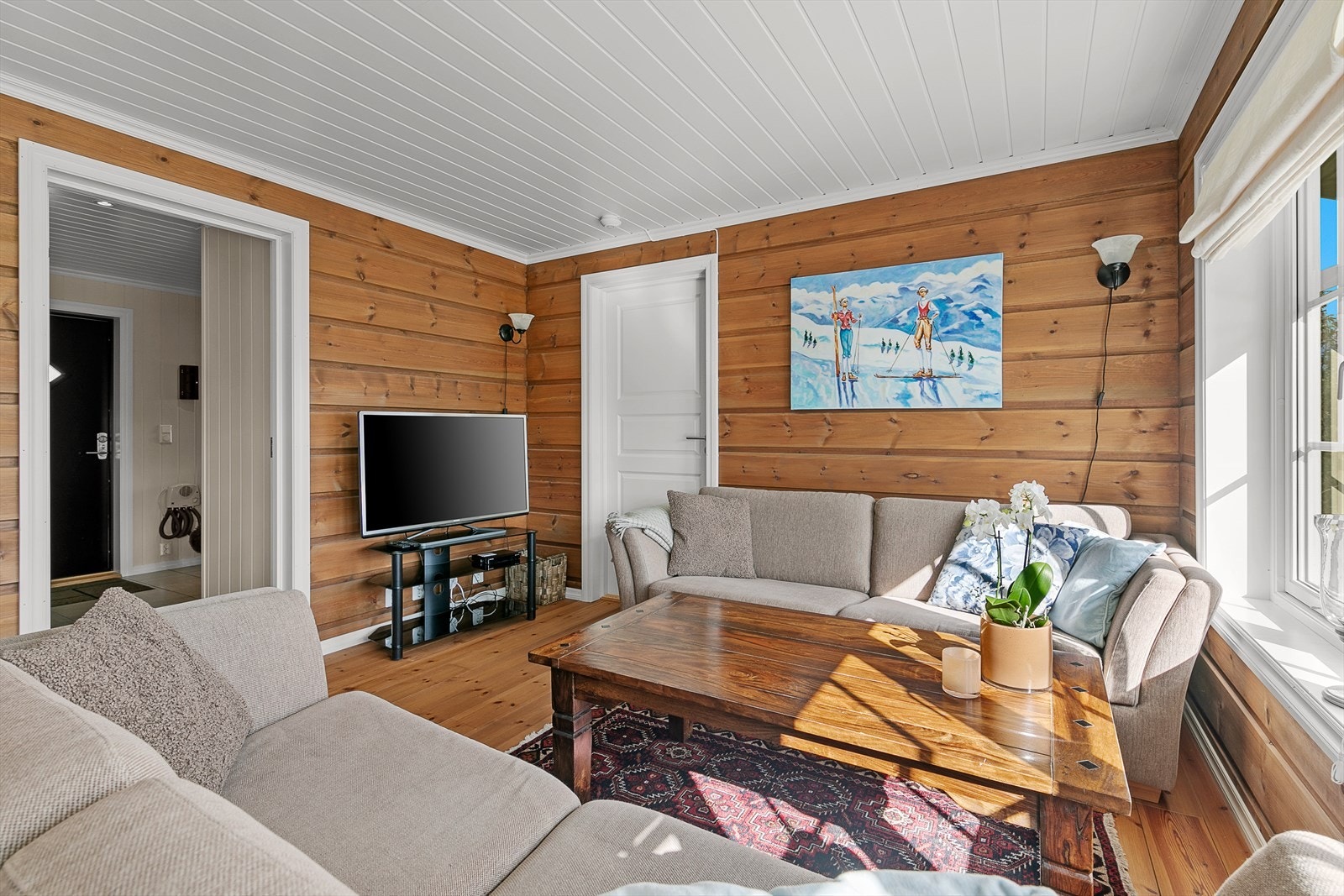 Koselig stue med vedovn og flere vinduer som gir godt med naturlig lys. Galleribilde